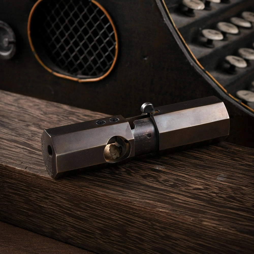 A horizontal profile of the Octagon Trigger lighter resting on wood, featuring a smooth glossy finish on its antiqued brass octagonal body.