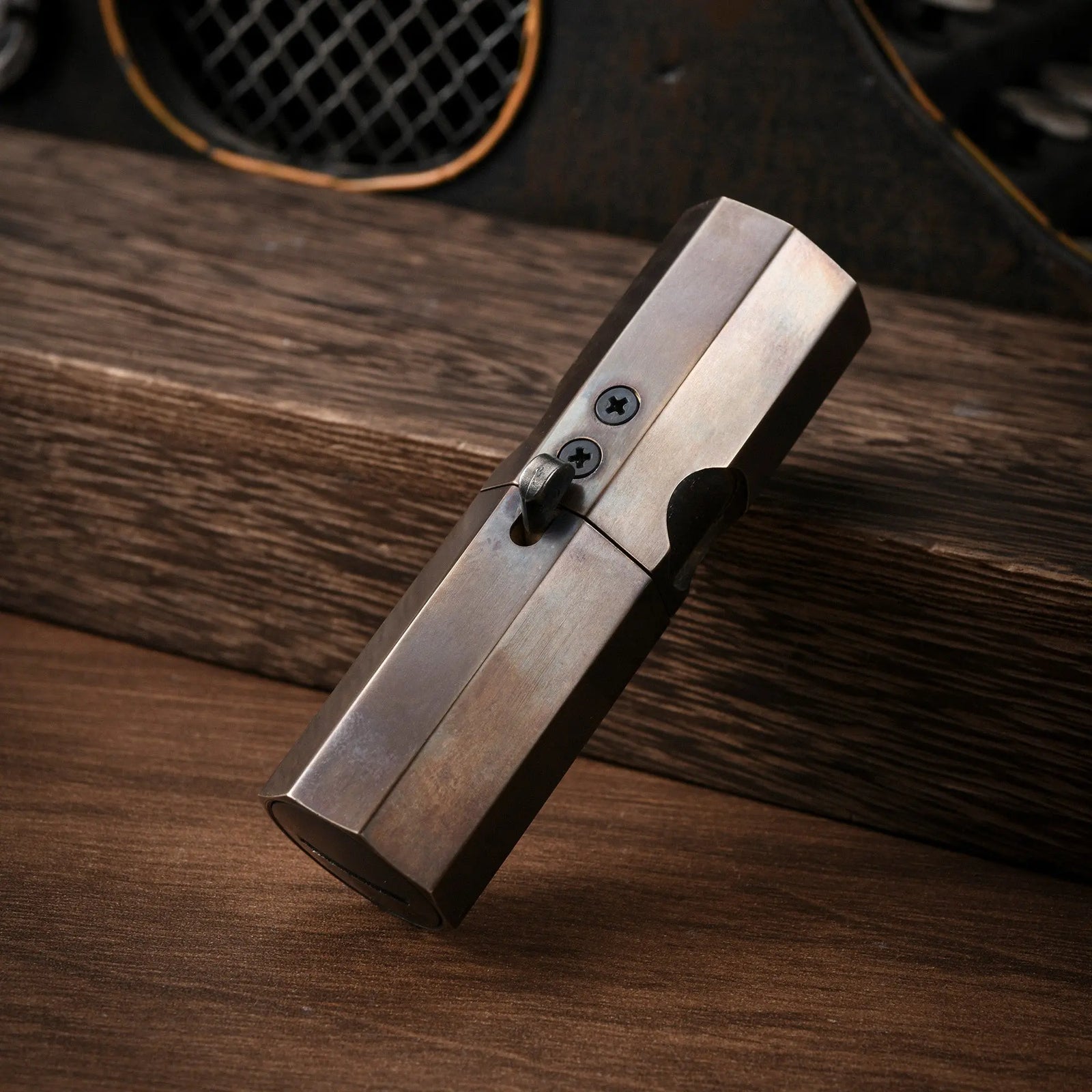A vertical standing Octagon Trigger lighter showing its smooth glossy finish, aged brass patina, and distinctive mechanical lever design.