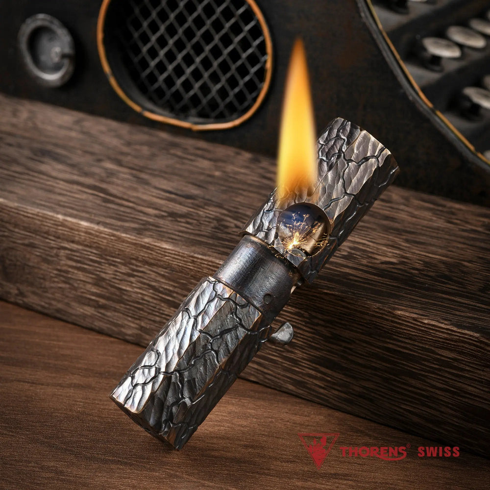 Hand-carved Octagon Trigger lighter ignited on a wooden surface, showcasing the earth fissure texture and brass mechanical ignition.