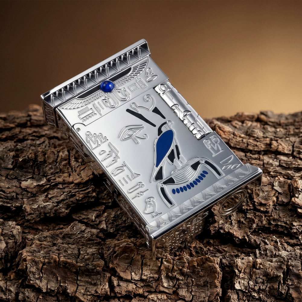 Standing Pharaoh's Light Silver lighter with a matte chrome finish, featuring deep-etched Egyptian motifs, a Falcon of Horus, and a blue gemstone.