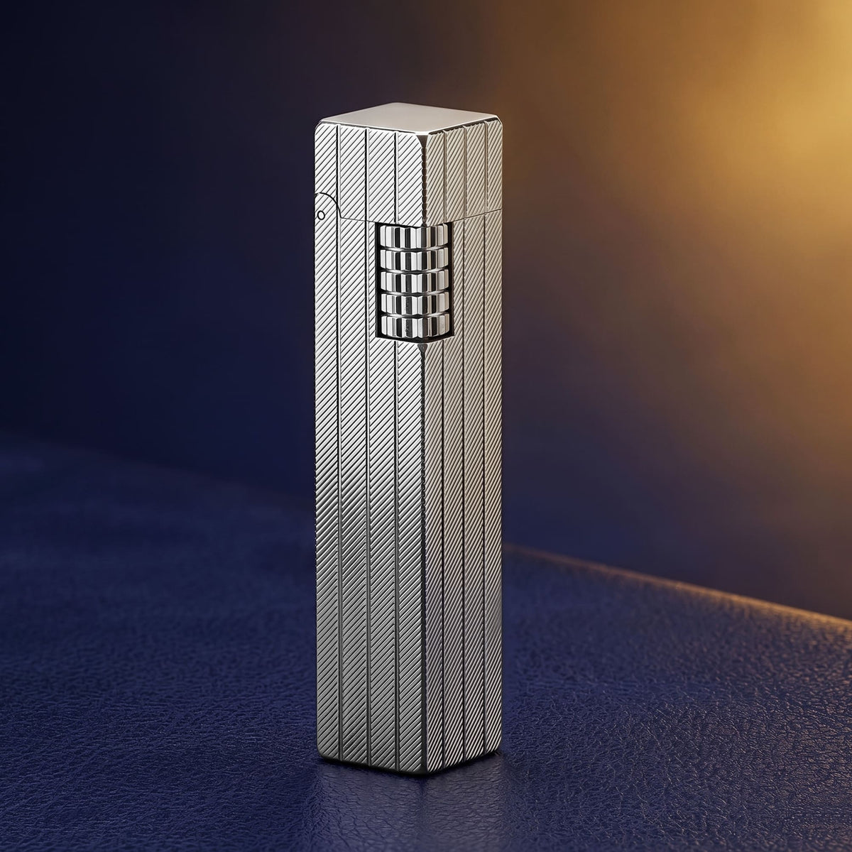 Thorens rectangular lighter in silver shown upright, featuring a diagonal engraved brass surface, vertical form, and precision side ignition wheel against a soft gradient background.