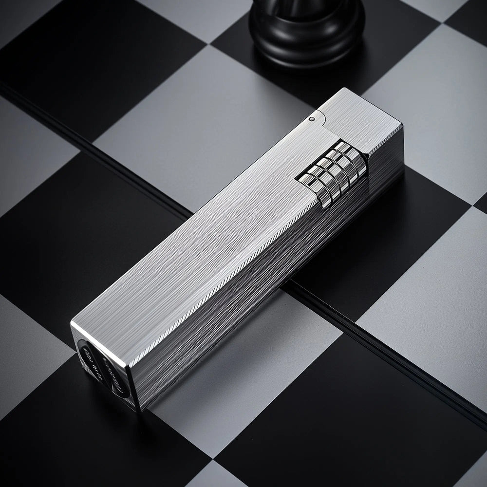 Glossy silver Thorens rectangular side-slip lighter shown in an angled closed view, featuring a linear brushed finish and exposed side ignition wheel on a black and white checkered surface