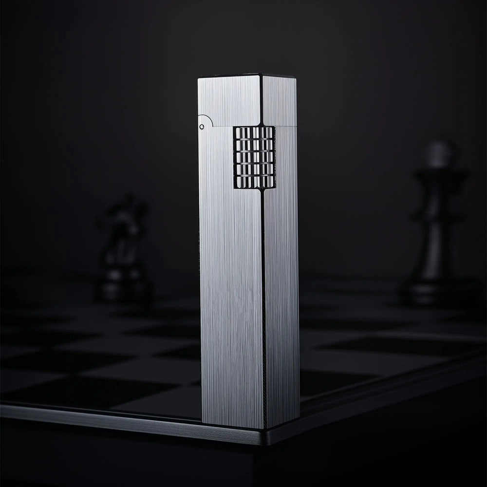 Glossy silver Thorens rectangular side-slip lighter standing upright in the closed position, featuring a brushed linear finish and exposed side ignition wheel against a dark checkered background