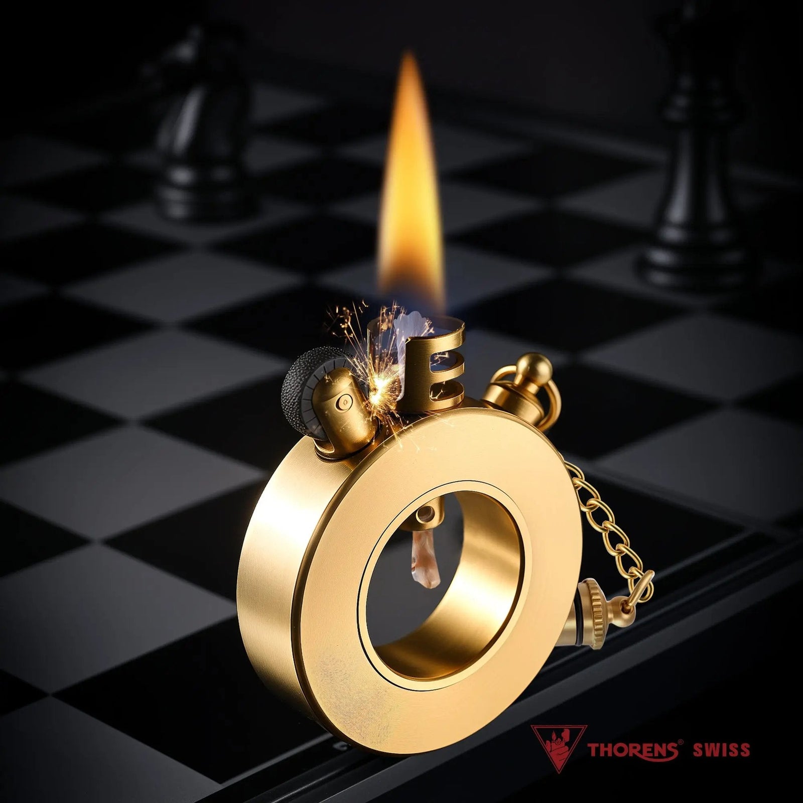 A Thorens Seahorse trench lighter in brushed brass standing on a chessboard, producing a tall, steady flame and sparks from its unique circular frame.