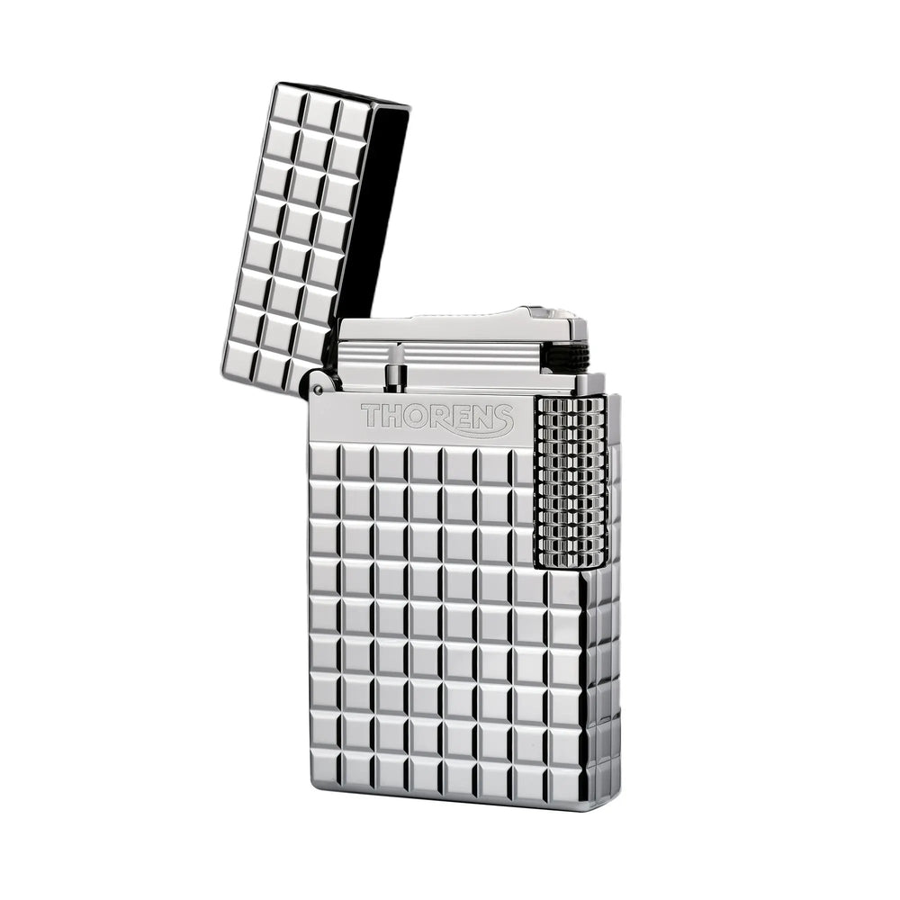 An open silver Thorens side slip lighter showing the internal flint mechanism and polished lid, featuring a high-shine argent blocks pattern and side roller.