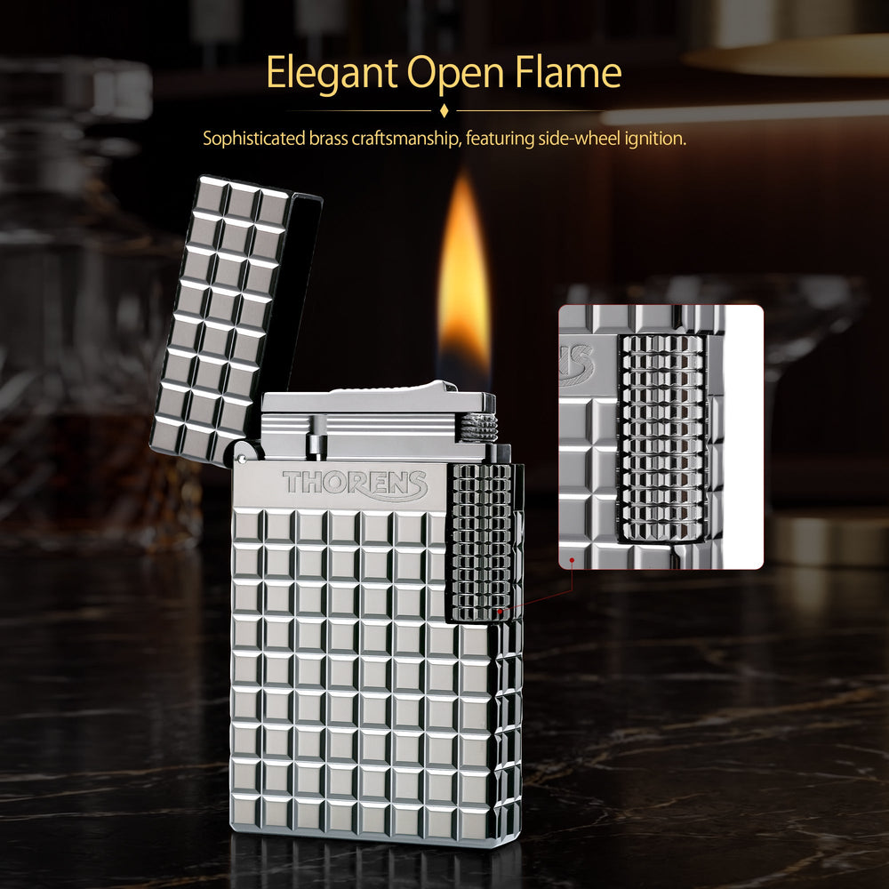 An open silver Thorens side slip lighter with a steady flame, highlighting the polished argent block texture, flint sparks, and side roller mechanism.