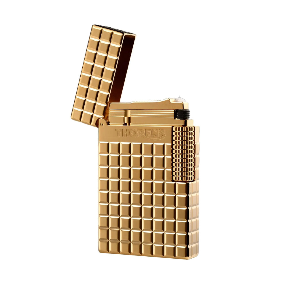 An open gold Thorens side slip lighter featuring a polished auric block pattern, a detailed view of the internal ignition mechanism, and a textured side roller.