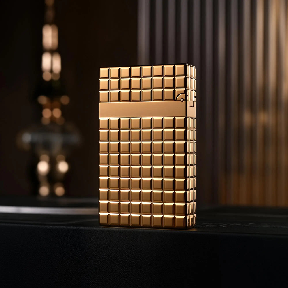The back of a gold Thorens side slip lighter, showcasing the seamless auric block pattern and high-polish finish across the brass body.