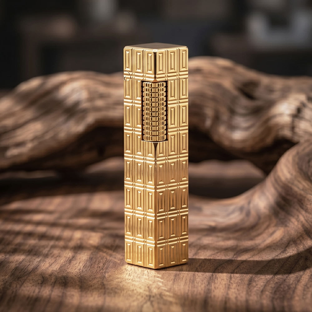 Thorens Side Slip rectangular lighter with geometric block pattern and extended roller in gold finish, standing upright on a wood surface with the engraved texture clearly visible.