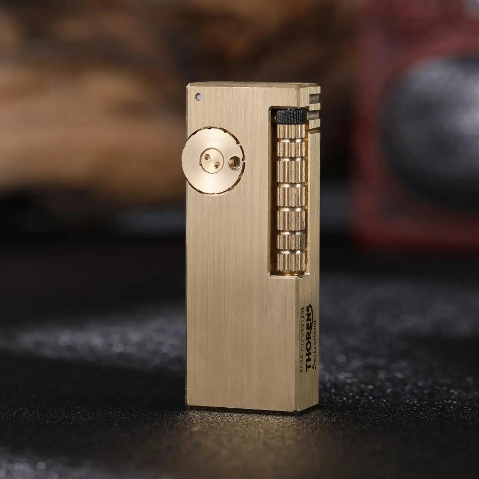 A front-facing shot of the Thorens Side Slip lighter in glossy brushed brass, highlighting the vertical mechanical wheel and the precision-milled circular adjustment dial.