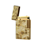 A studio product shot of the Thorens Side Slip lighter in gold, featuring an intricate Vortex engraved pattern and premium brass construction. The lid is flipped open to showcase the precision mechanical flint wheel and internal components, reflecting a refined EDC aesthetic.