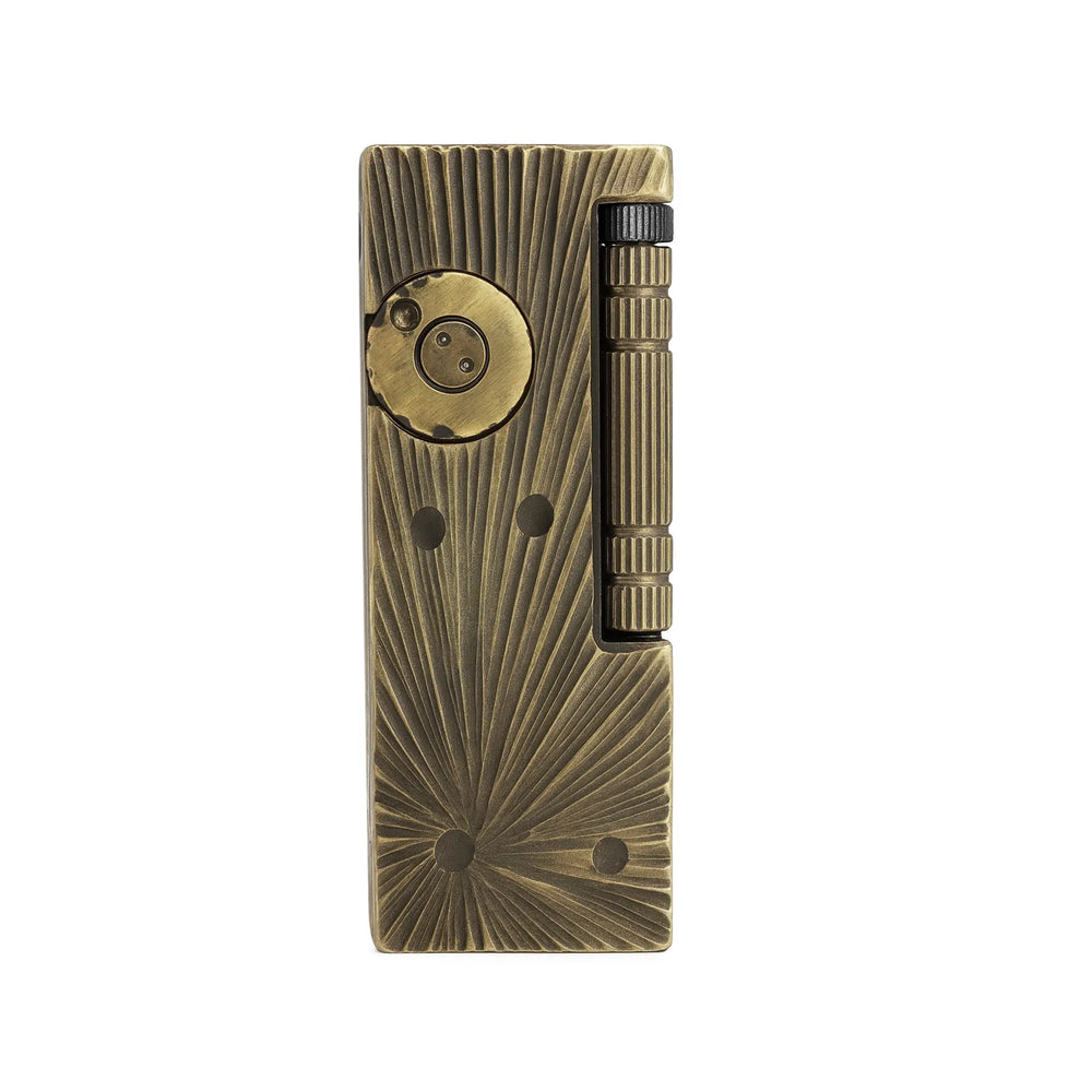 A Thorens Side Slip lighter with a vintage brass finish, featuring a textured meteorite crater engraving and a vertical roller ignition, isolated on a clean white background.