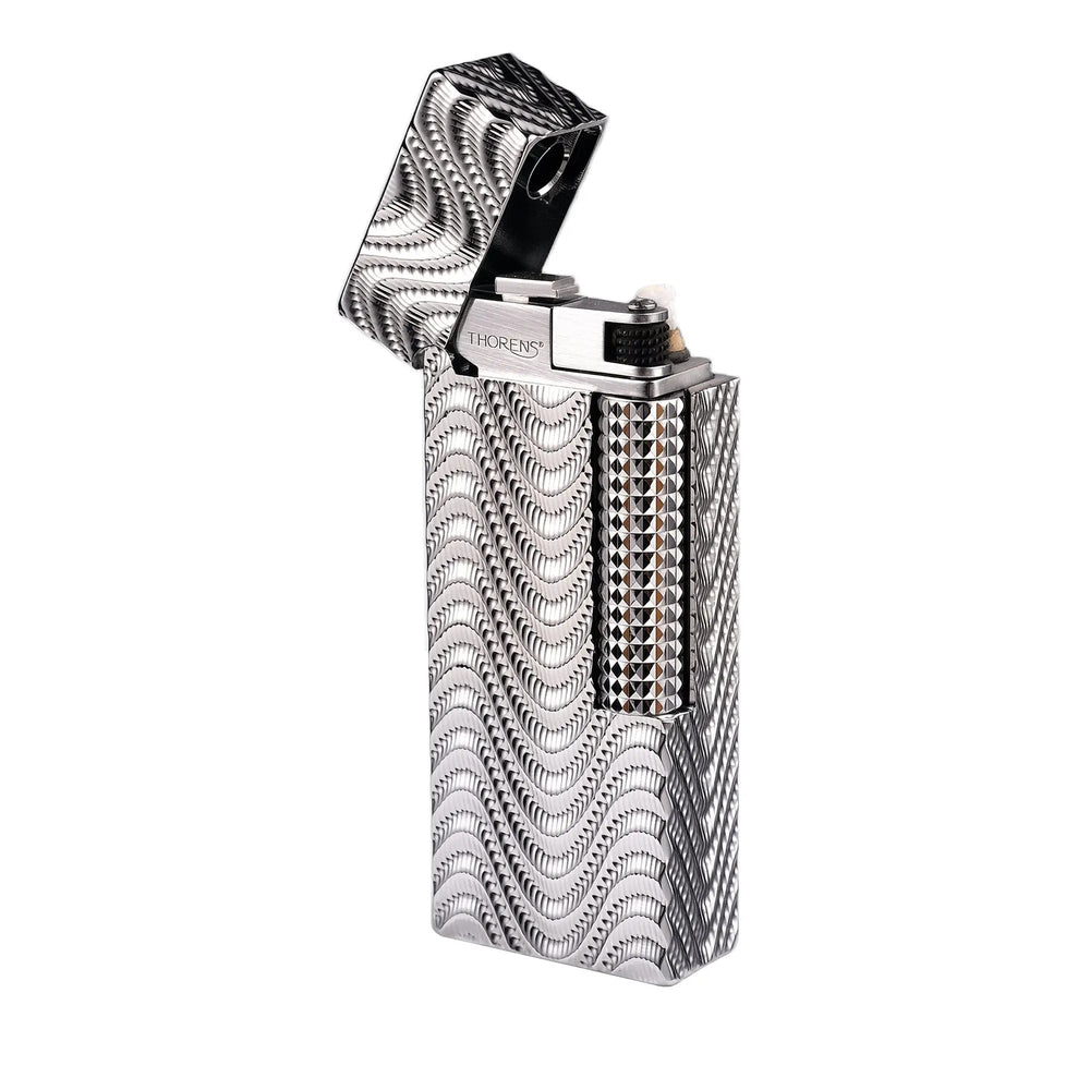 An open Argent Mirage narrow lighter against a white background, featuring a high-density wavy "mirage" texture across its silver body, a polished internal chimney with the Thorens logo, and a diamond-cut ignition roller.