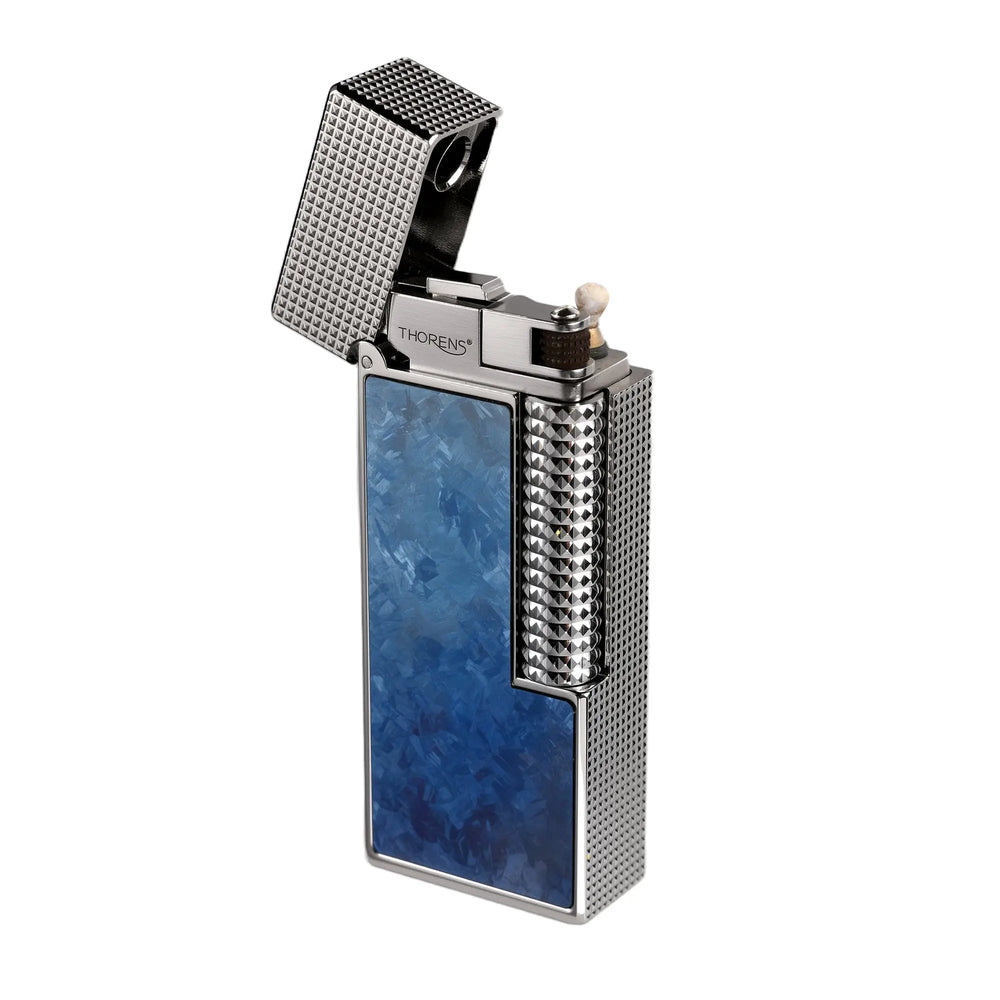 A profile view of the open Blue Frost Ti narrow lighter, highlighting the crystalline blue faceplate, silver hobnail body, and the precision-machined Thorens ignition mechanism.