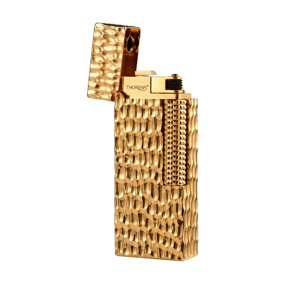 An open Golden Crater narrow lighter in a gold finish, showing the hammered crater texture and the Thorens logo on the internal ignition head.
