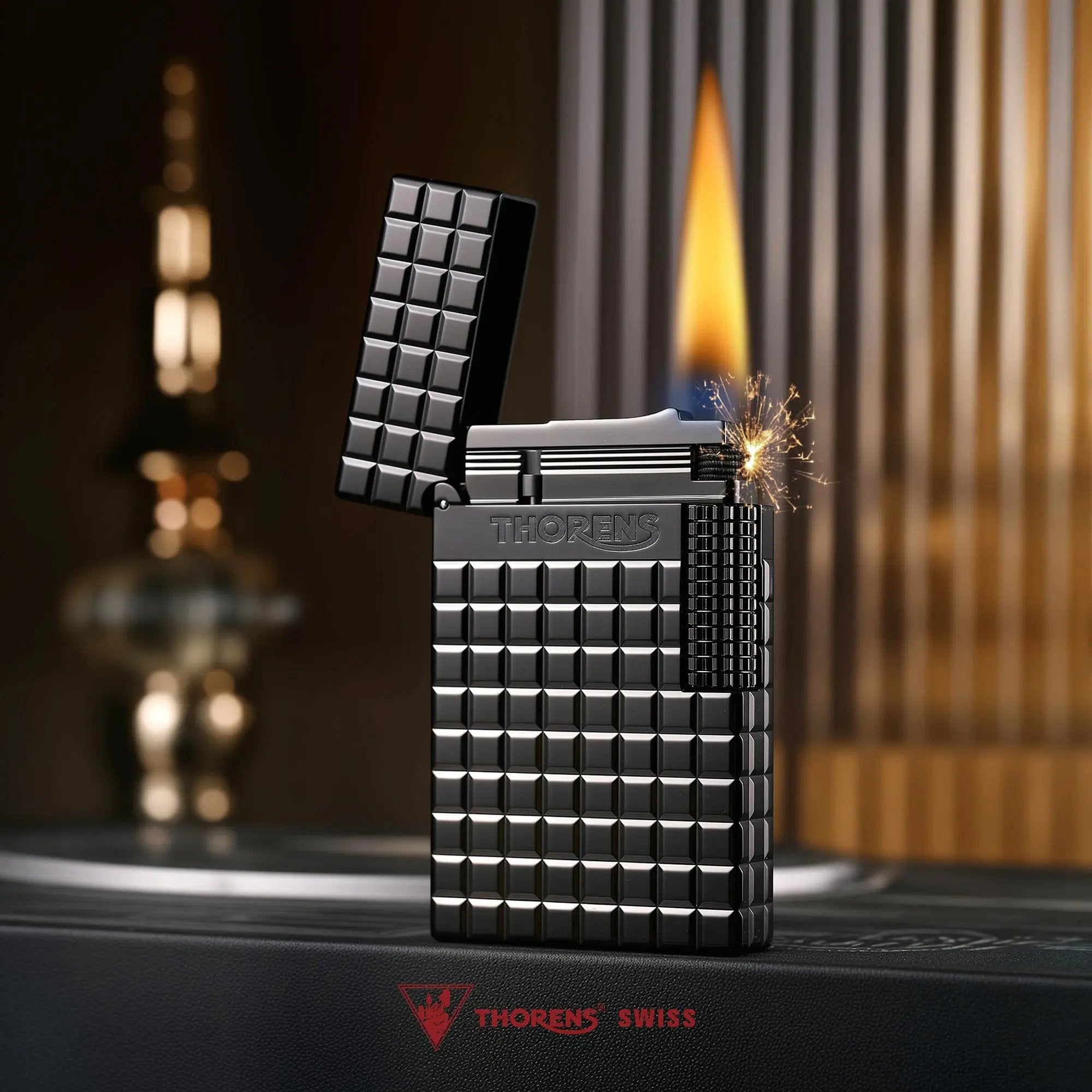 An open Thorens side slip lighter in matte onyx black, showing an active flame and flint sparks against the textured block pattern and side roller.