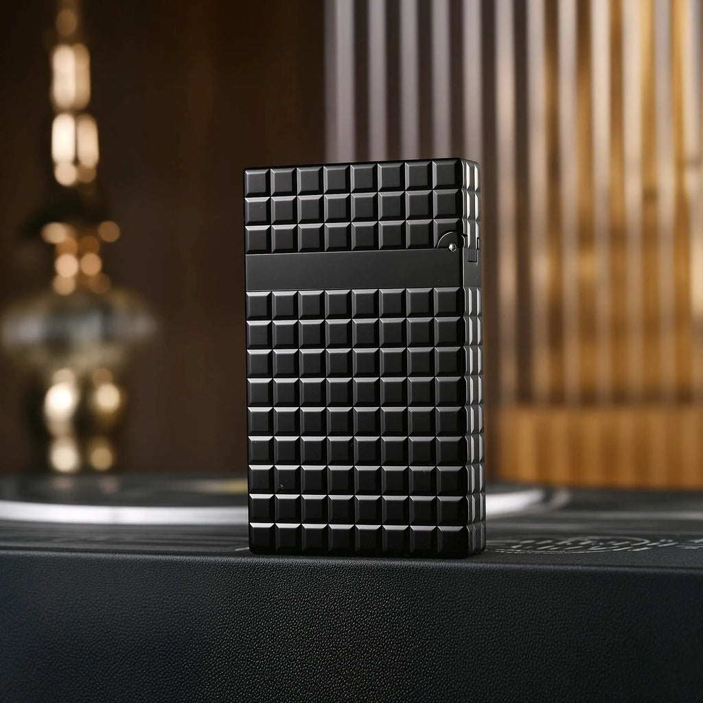 The back of an onyx black Thorens side slip lighter, showcasing the continuous matte block pattern and refined mechanical construction.