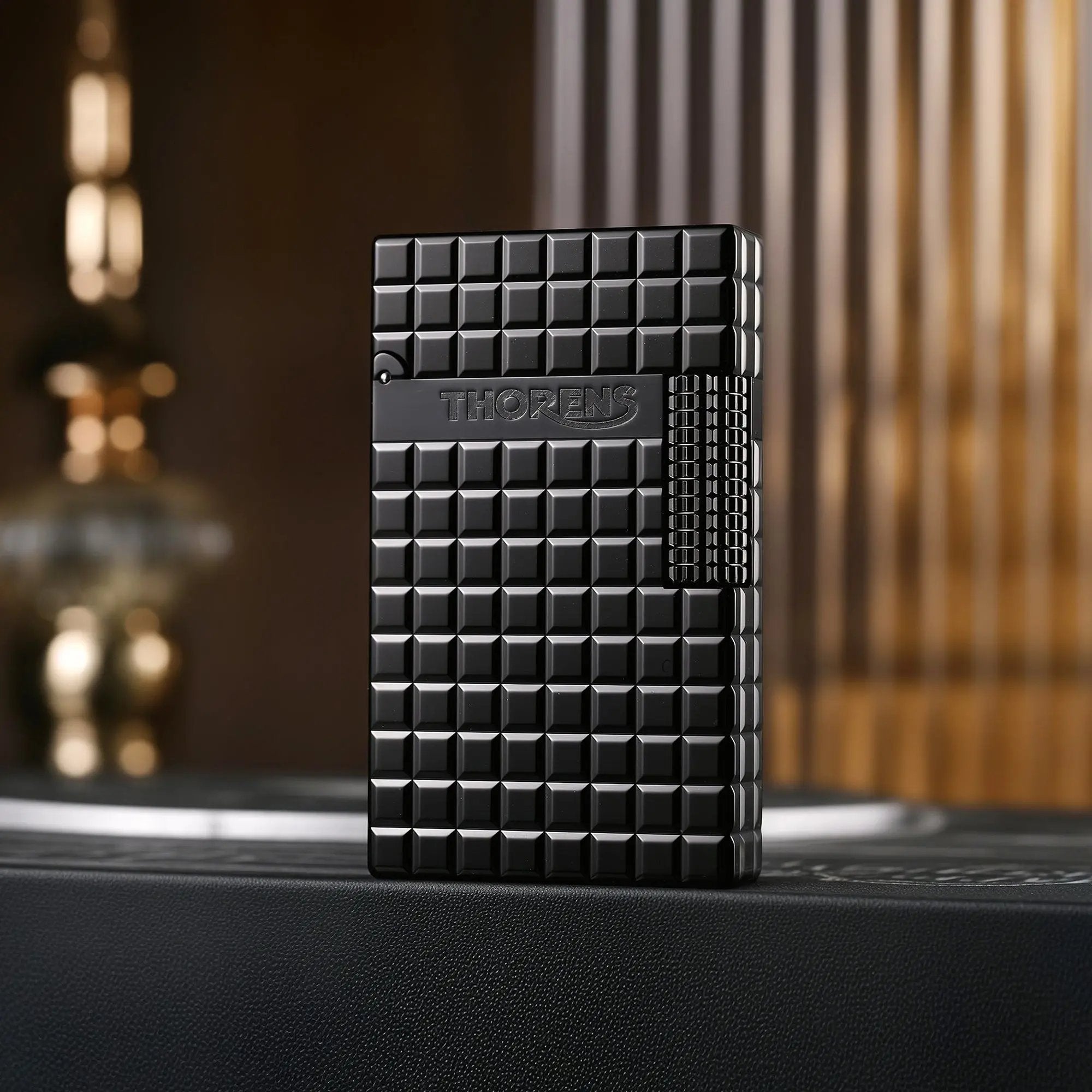 A closed black Thorens side slip lighter featuring a matte onyx block pattern, side-roller ignition, and engraved Thorens branding.