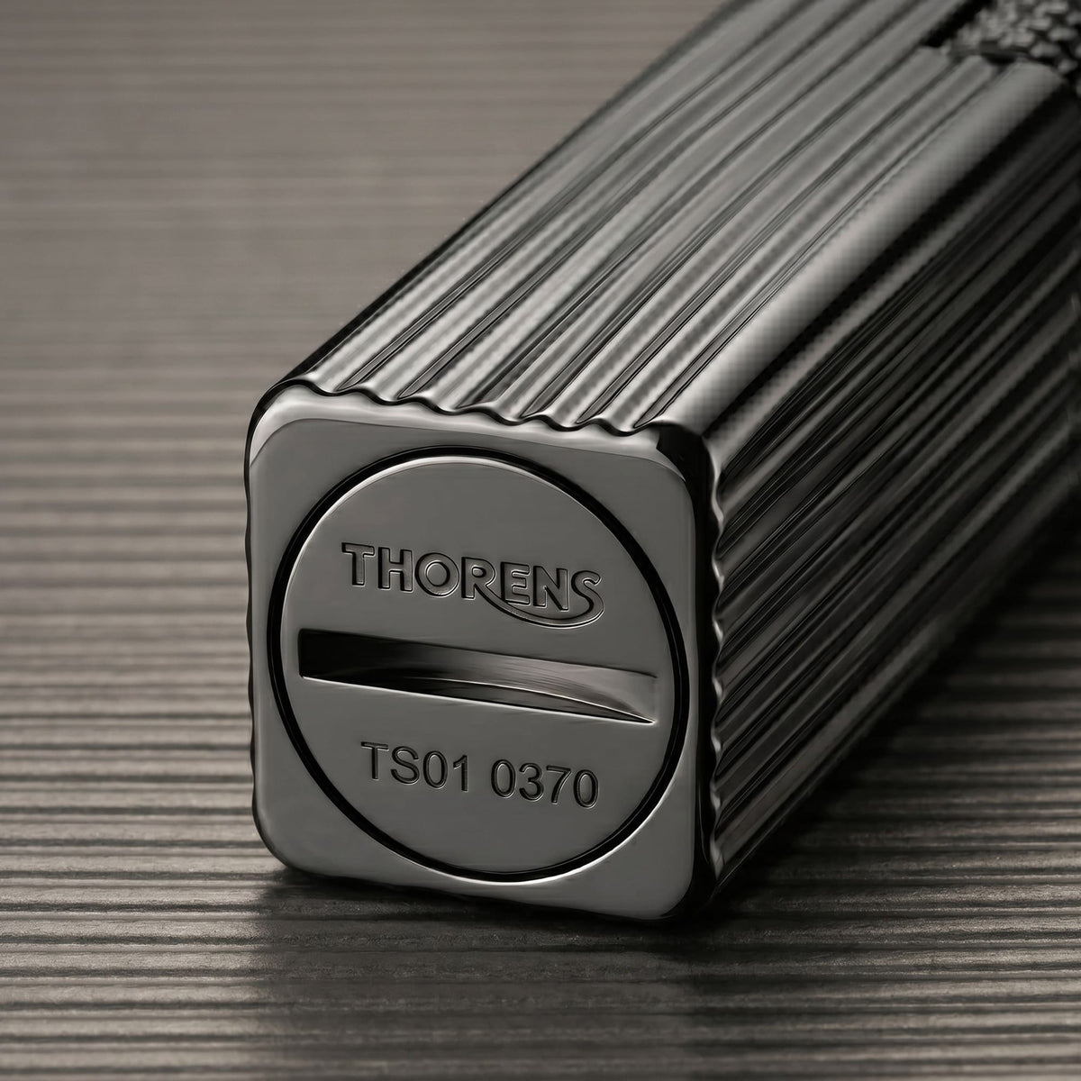 Thorens Side Slip rectangular lighter in black pinstripe finish showing engraved base plate with fuel slot and precision metal construction.