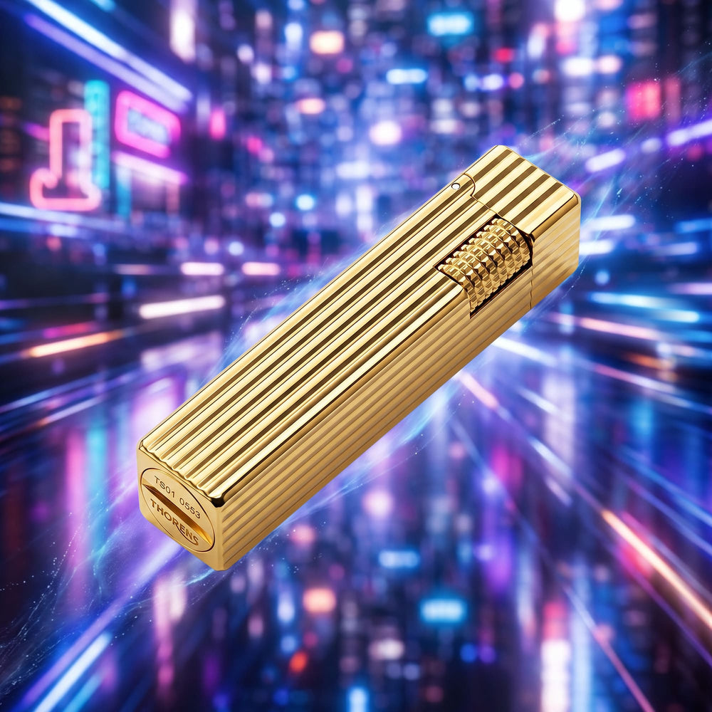 Thorens Side Slip rectangular lighter in gold pinstripe finish shown at an angled view, highlighting linear texture and integrated ignition wheel against a vibrant blurred background.