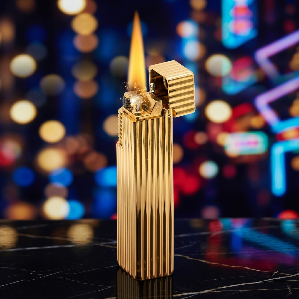Thorens Side Slip rectangular lighter in gold pinstripe finish igniting with flame and spark, lid open to reveal flint wheel and wick against a blurred night background.