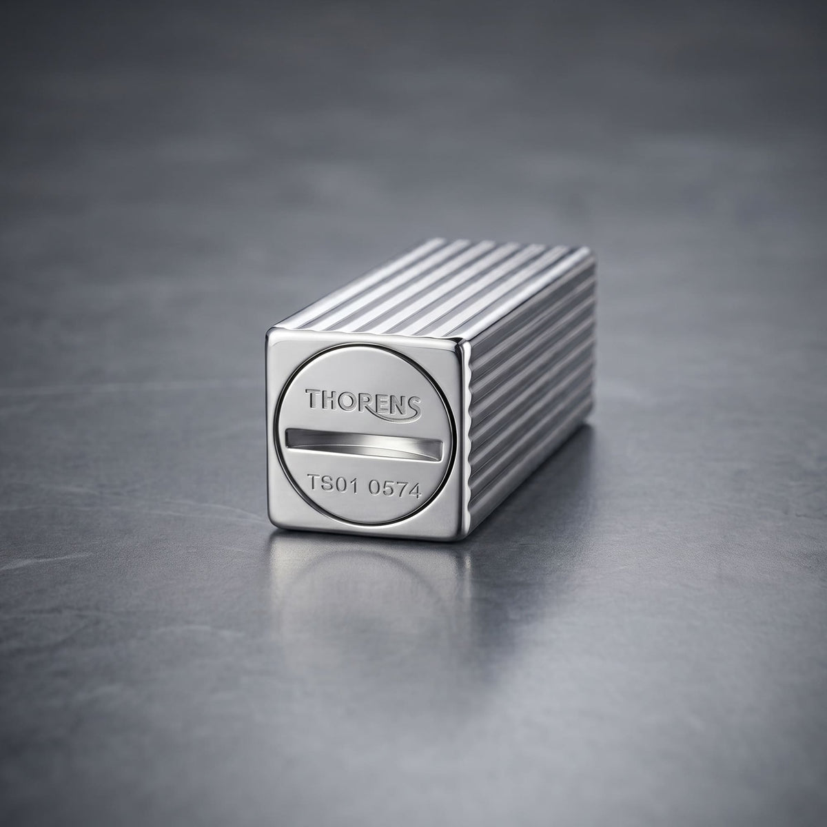 Thorens Side Slip rectangular lighter in silver pinstripe finish focused on the base, showing engraved logo and refill slot with clean linear brass construction.