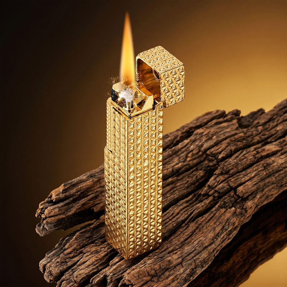 Thorens rectangular lighter with gold starburst pattern and extended roller shown ignited on textured wood, lid open with visible spark and flame.