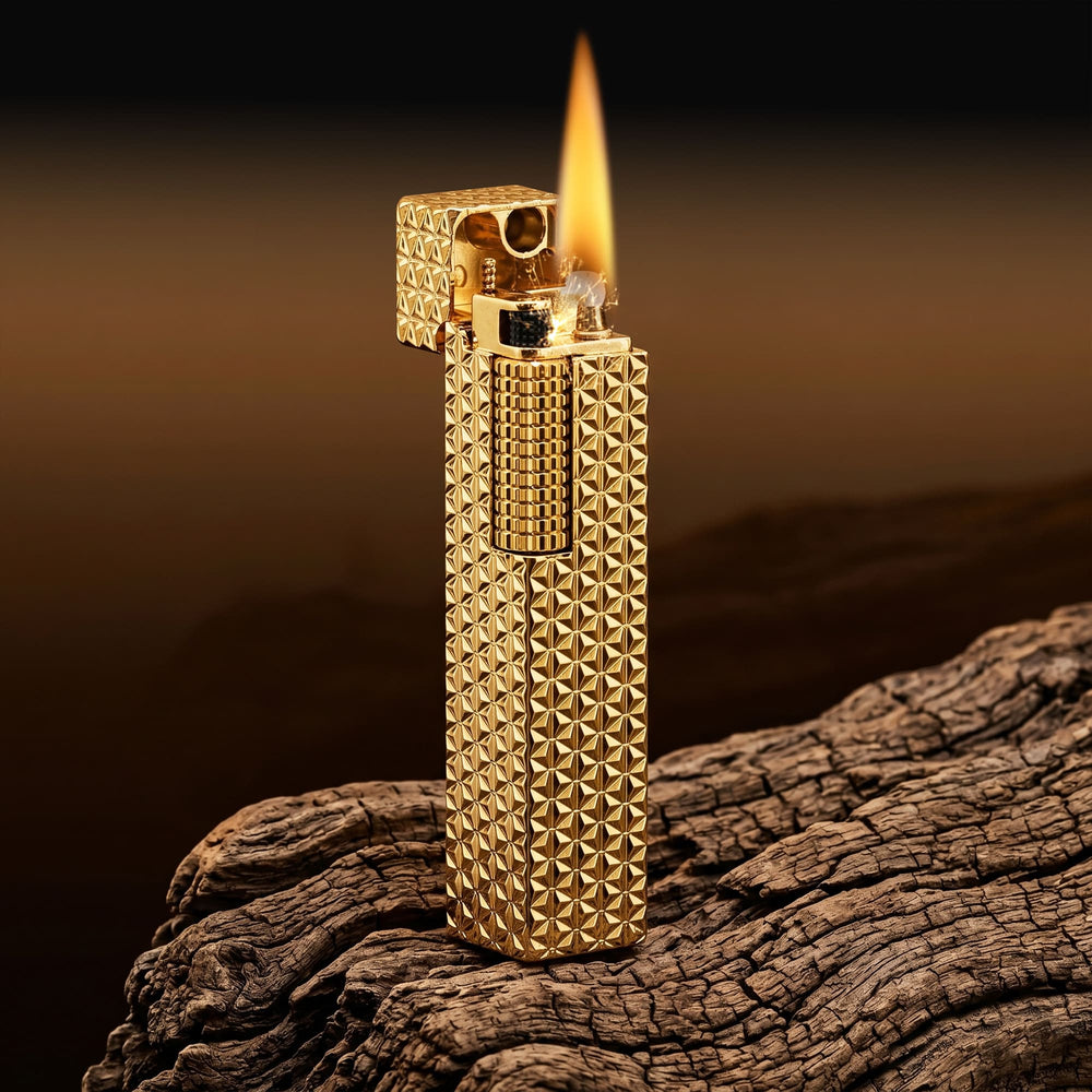 Thorens rectangular lighter with gold starburst pattern and extended roller shown open and ignited, highlighting spark, flame, and engraved brass texture.