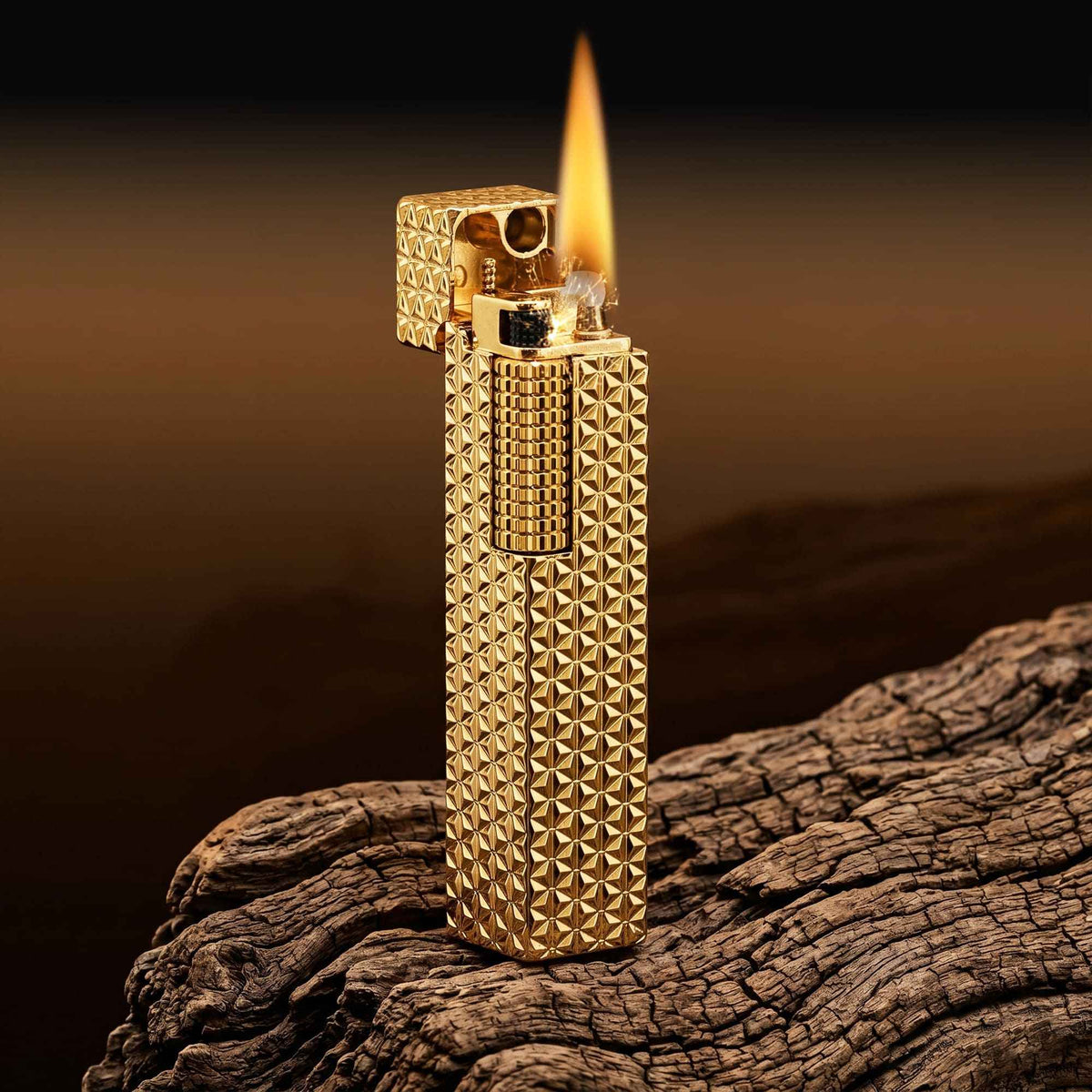 Thorens rectangular lighter with gold starburst pattern and extended roller shown open and ignited, highlighting spark, flame, and engraved brass texture.