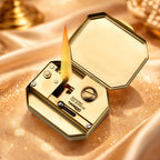 Thorens Steampunk Matchbox Twin Torque lighter open and lit, showing flame, brass inner structure, and removable fuel reservoir on a vintage textured surface.