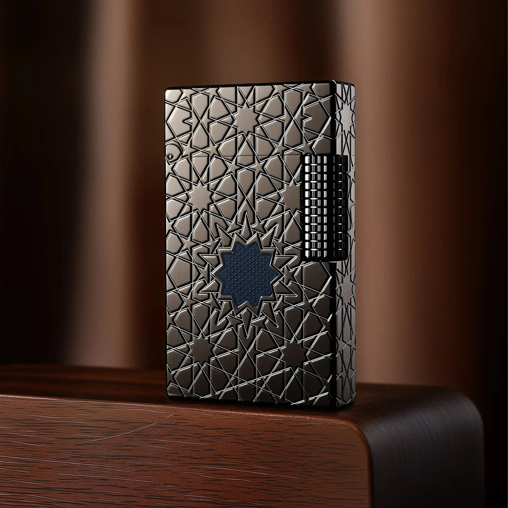 A Thorens Stellar Mesh Black lighter featuring an intricate geometric star engraving and central blue mesh detail, resting on a dark wood pedestal.