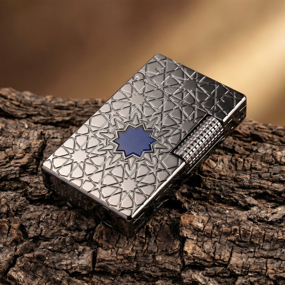 A Thorens Stellar Mesh Black lighter featuring an intricate geometric star engraving and central blue mesh detail, resting on a dark wood pedestal.