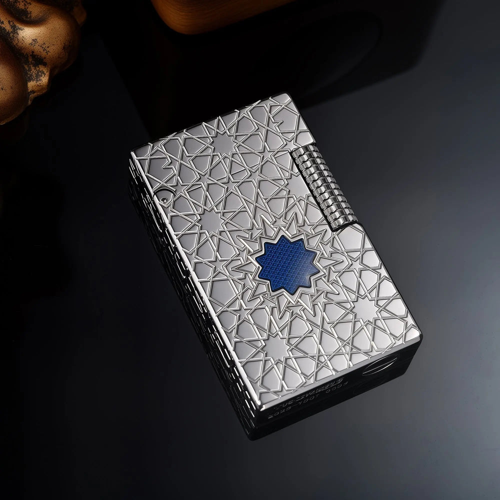 A top-down view of the Thorens Stellar Mesh Silver lighter on a dark reflective surface, highlighting the precision-engraved star patterns and the vibrant blue mesh center.