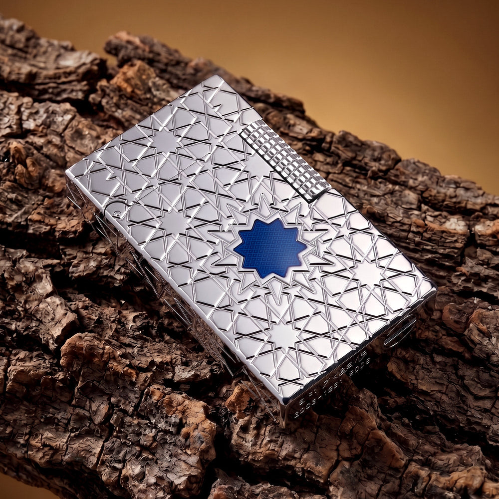 A top-down view of the Thorens Stellar Mesh Silver lighter on a dark reflective surface, highlighting the precision-engraved star patterns and the vibrant blue mesh center.