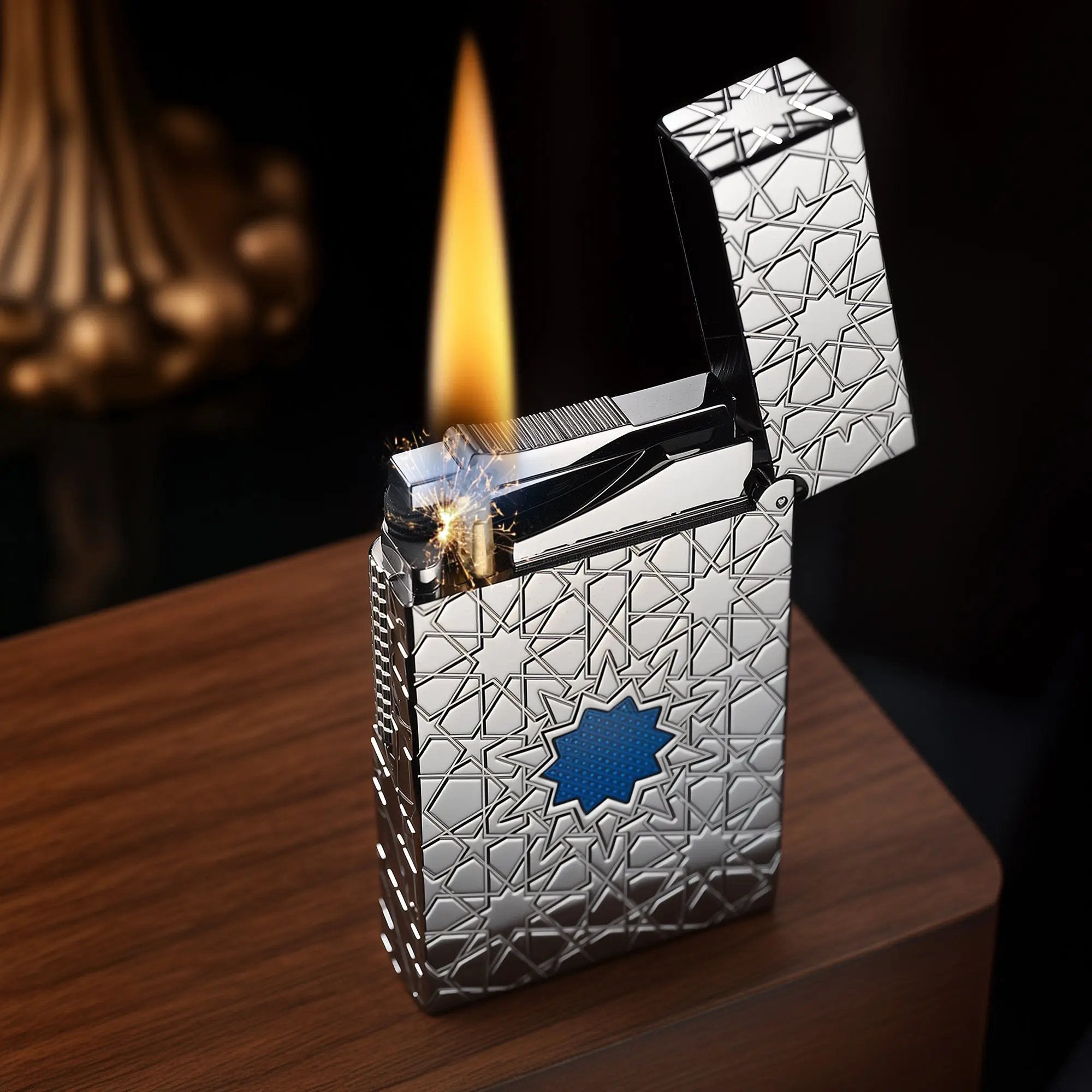 A Thorens Stellar Mesh Silver lighter resting on a wooden surface with an open lid, highlighting the mechanical flint spark and a clean flame against the silver geometric star pattern.