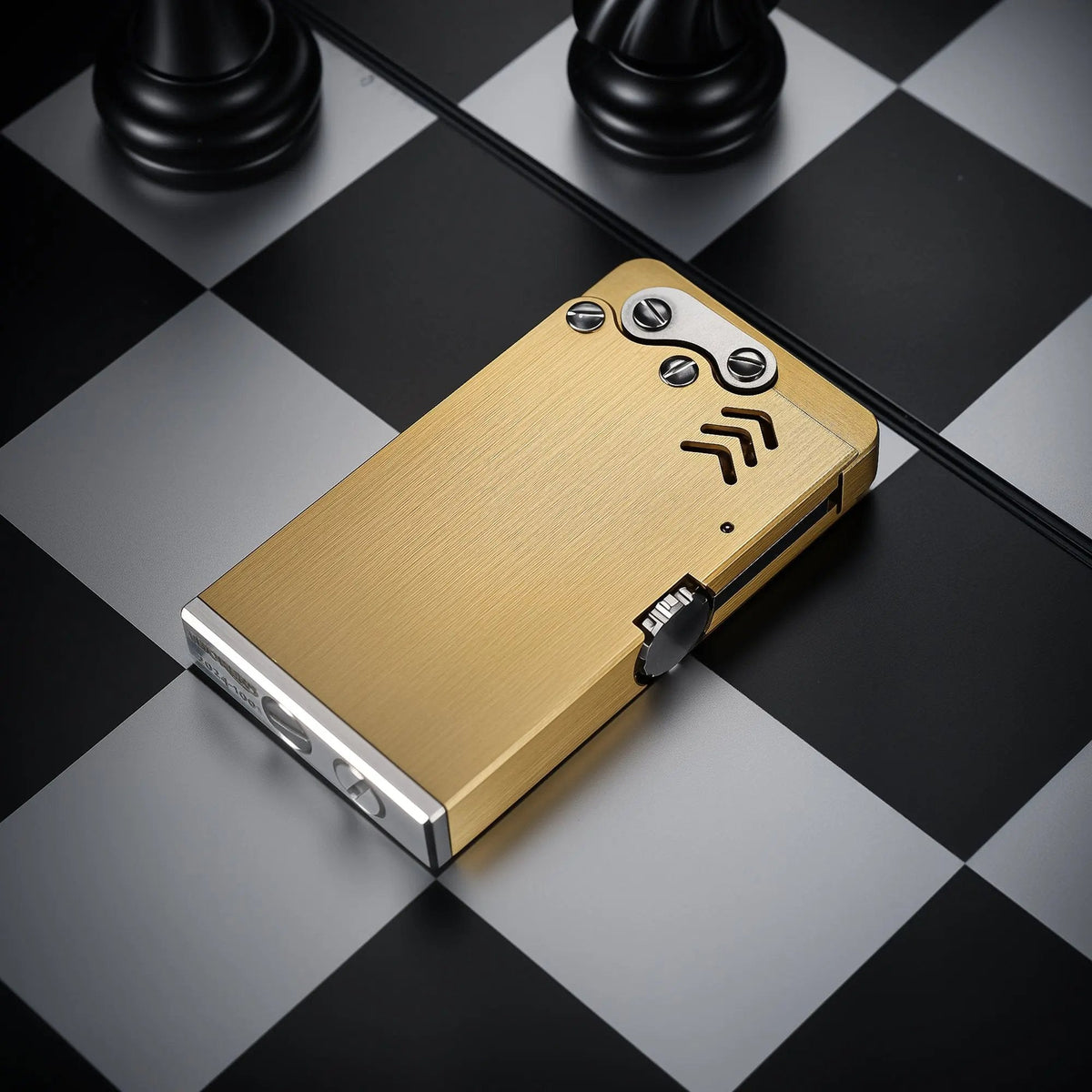 Slim Thorens ejection lighter featuring a brushed brass body and mechanical screw accents, displayed on a black and white checkered surface.