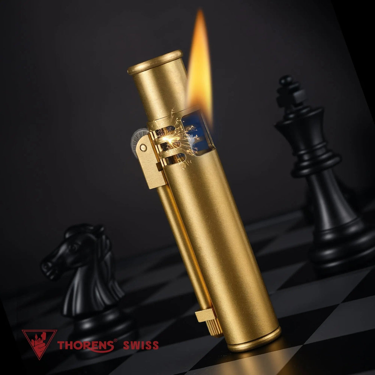 A detailed view of an ignited Torch Stick brass lighter with a vertical flame and visible ignition sparks on a dark chessboard background.
