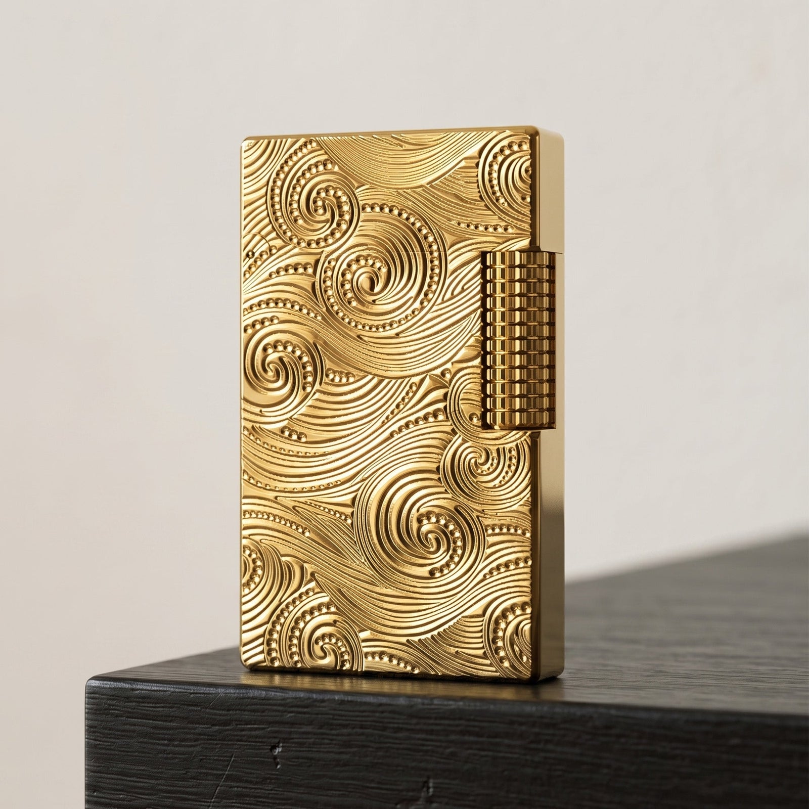 A close-up of a gold Thorens vortex-engraved lighter resting on a leather surface, highlighting the authentic brand logo and serial number engraved on the bottom.