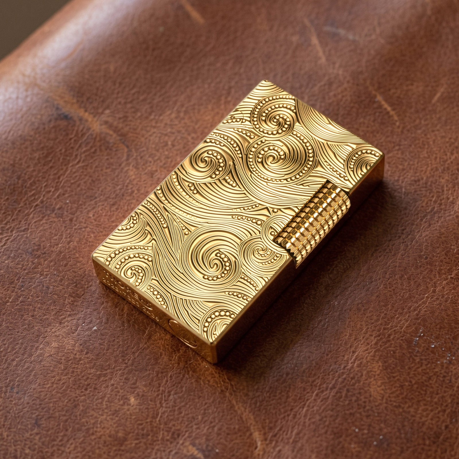 A person holding a Thorens gold vortex engraved lighter, demonstrating its compact size and ergonomic design for comfortable everyday carry.